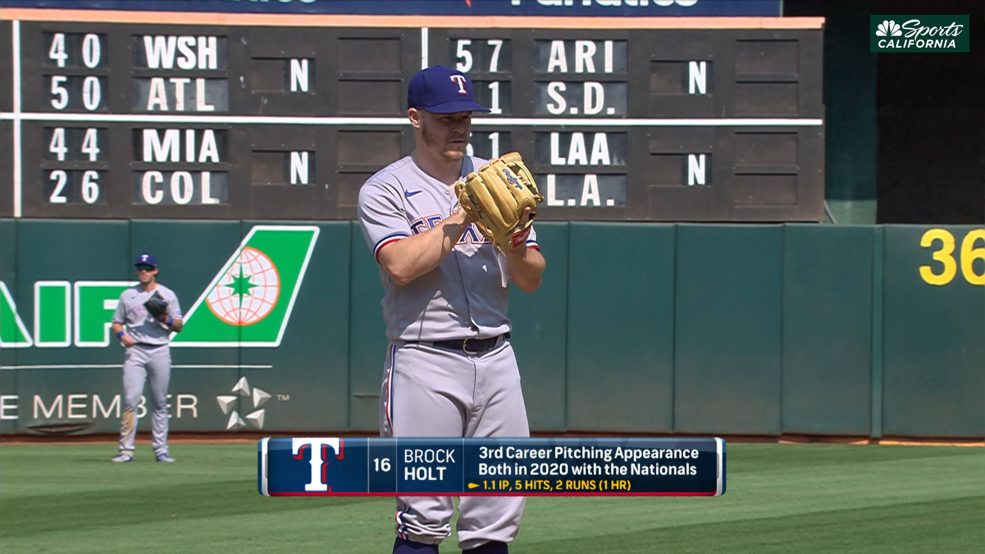 Texas Rangers third baseman Brock Holt (16) blows a bubble during