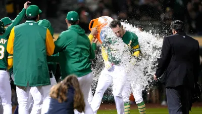 Brent Rooker #25 of the Oakland Athletics celebrates with teammates after hitting a walk-off three-run home run to defeat the Texas Rangers 9-7 in the bottom of the 10th inning at RingCentral Coliseum on May 12, 2023 in Oakland, California.