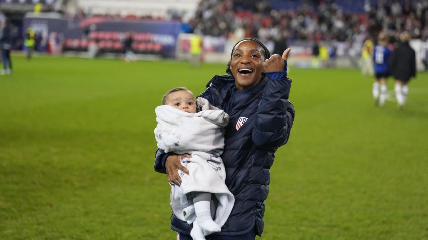 Crystal Dunn holding her baby on the field