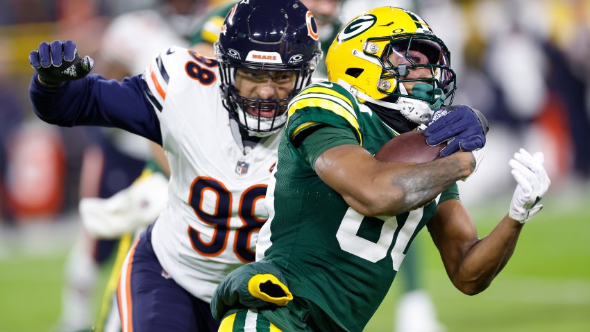GREEN BAY, WISCONSIN – JANUARY 07: Bo Melton #80 of the Green Bay Packers runs the ball while being chased by Montez Sweat #98 of the Chicago Bears during the third quarter at Lambeau Field on January 07, 2024 in Green Bay, Wisconsin. (Photo by John Fisher/Getty Images)
