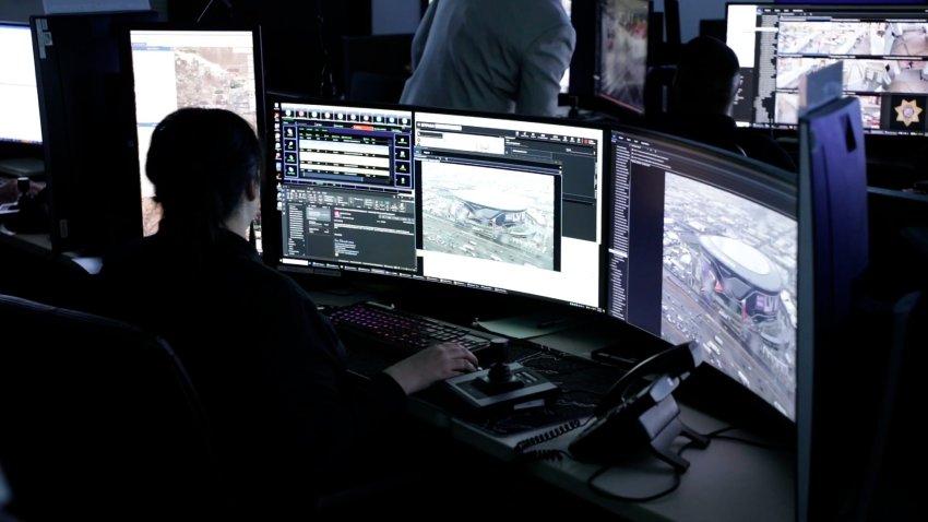 Person works at computers in dark command room for FBI surveillance