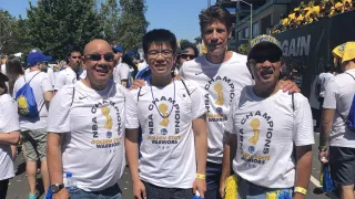 Golden State Warriors Season Ticket Holder representative Don Moffett poses for a photo with the Wong family at an NBA championship parade.