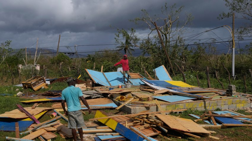Residents stand on the wreckage of a house destroyed by Hurricane Melissa in Santa Cruz, Jamaica, Wednesday, Oct. 29, 2025.