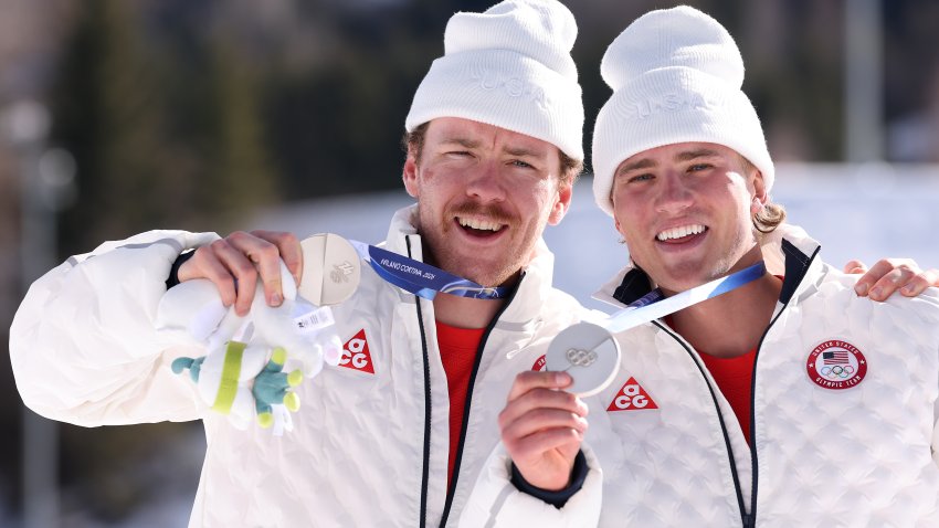 VAL DI FIEMME, ITALY – FEBRUARY 18: Silver medalists Ben Ogden and Gus Schumacher of Team United States pose for a photo during the medal ceremony for Men’s Team Sprint Free Finals on day twelve of the Milano Cortina 2026 Winter Olympic games at Tesero Cross-Country Skiing Stadium on February 18, 2026 in Val di Fiemme, Italy. (Photo by Lars Baron/Getty Images)