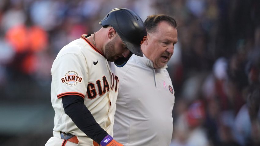 Jul 27, 2026; San Francisco, California, USA; San Francisco Giants third baseman Casey Schmitt (left) walks off the field with head of medical and performance Dave Groeschner (right) after suffering an injury during the second inning against the Milwaukee Brewers at Oracle Park. Mandatory Credit: Darren Yamashita-Imagn Images