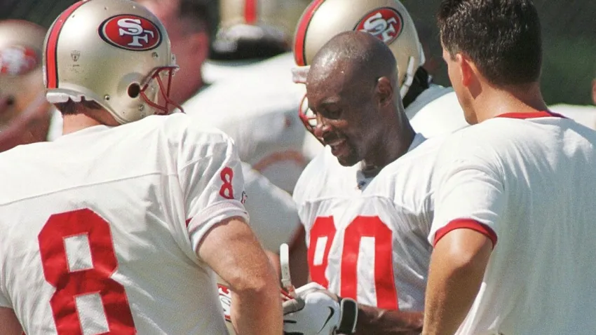 ROCKLIN, UNITED STATES:  San Francisco 49ers wide-receiver Jerry Rice (C) goes over plays with 49ers quarterback Steve Young (L) during training camp 21 July in Rocklin, California.   AFP PHOTOS/John G.  MABANGLO (Photo credit should read JOHN G. MABANGLO/AFP via Getty Images)