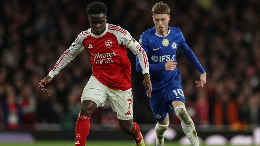 Arsenal's English midfielder #07 Bukayo Saka (L) is challenged by Chelsea's English midfielder #10 Cole Palmer (R).